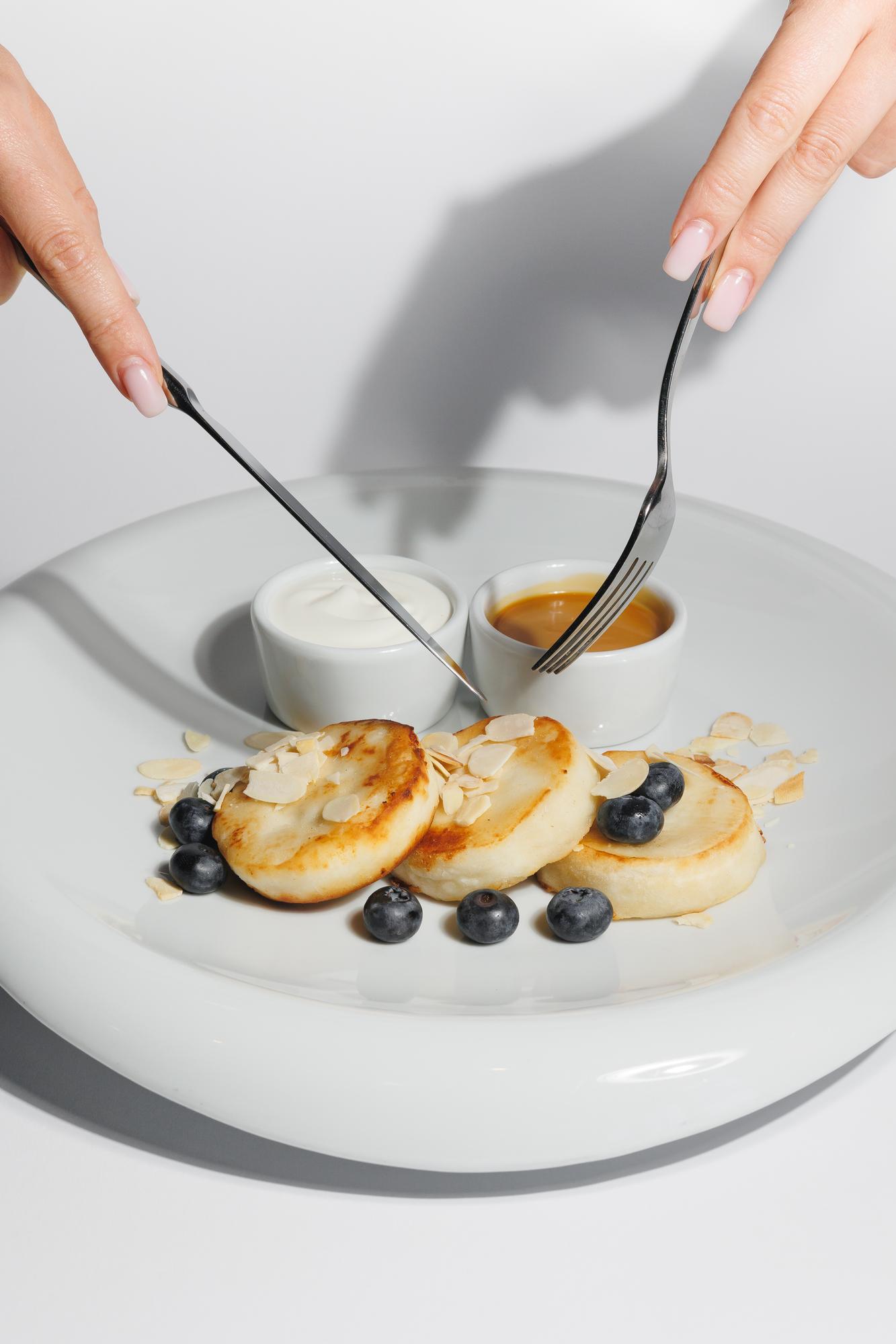 closeup of hands garnishing dessert
